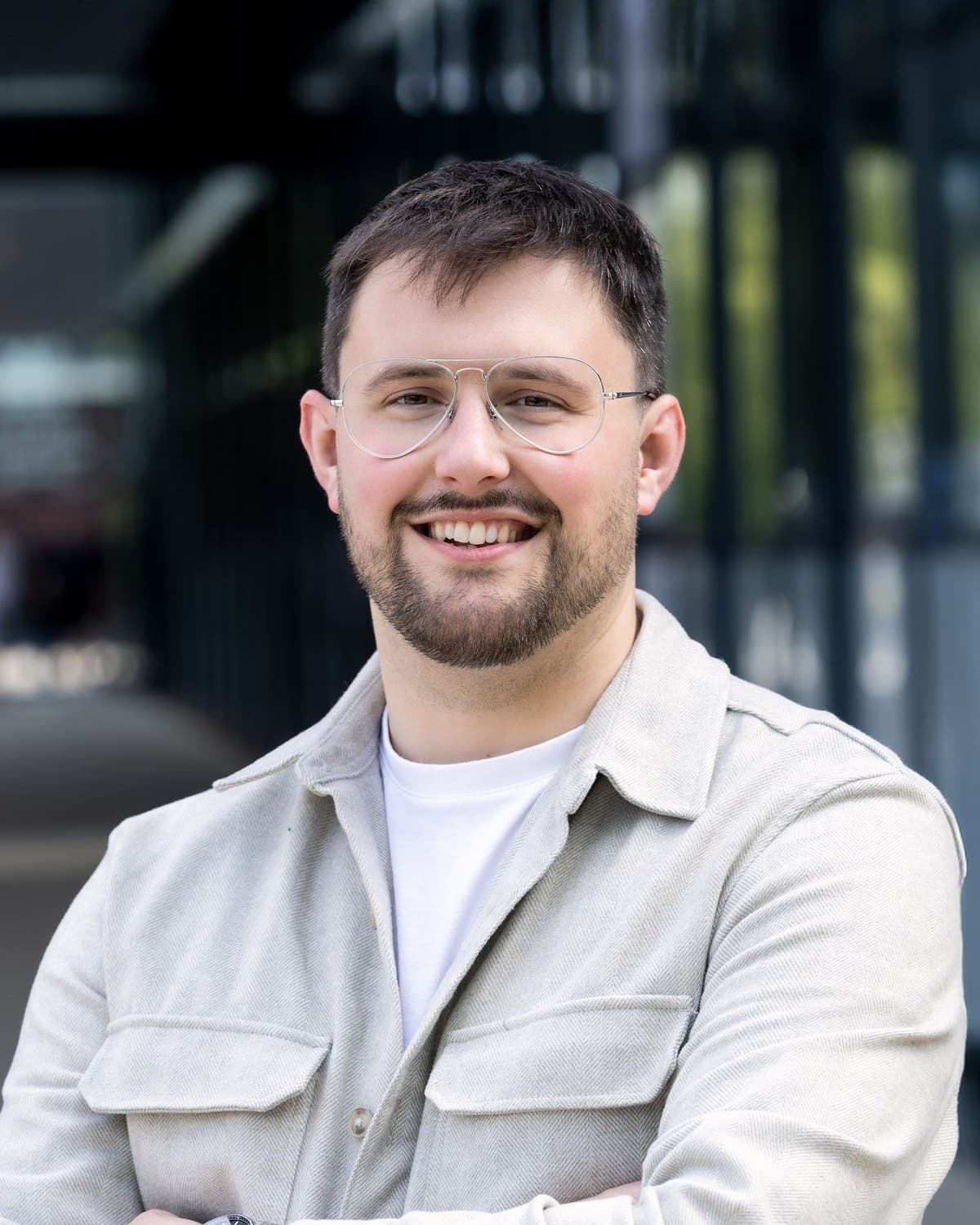 A smiling member of the Identity Agency team, arms folded, photographed outside the studio building.